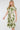 Woman wearing a green and white patterned dress on a white background